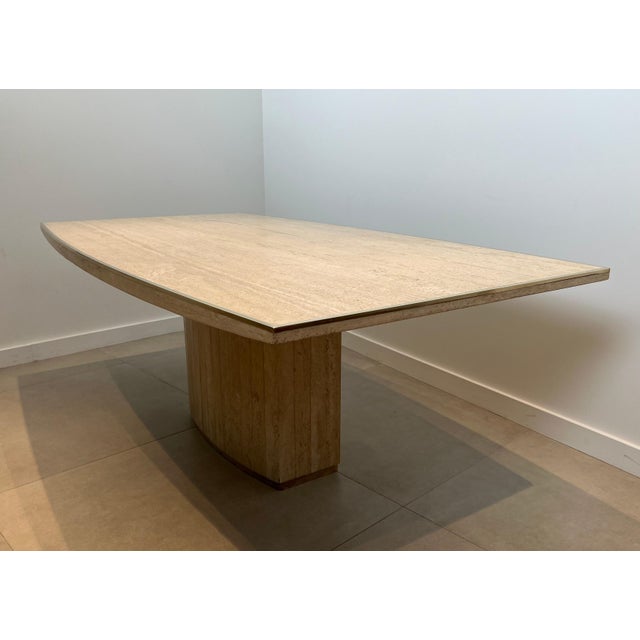 This beautiful and very elegant barrel shaped dining table is made up of a very beautiful travertine top with a brass net...