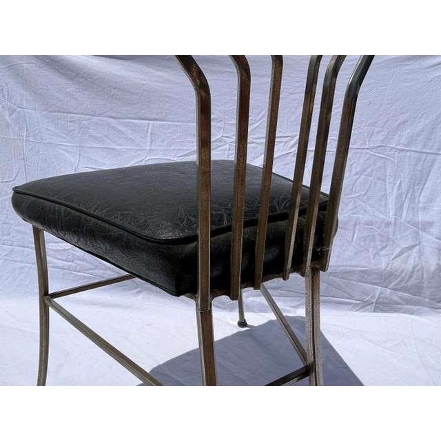 Geometric single chair with geometric back splat and faux black leather seat.