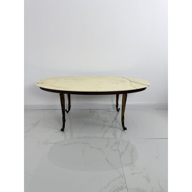 Oval coffee table with marble top, 1950s Brass and bronze legs. Intact and in good condition with minor signs of wear....