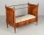 A 19th century French Napoleon III Period child's bed made of solid cherry wood, with column form supports and iron...