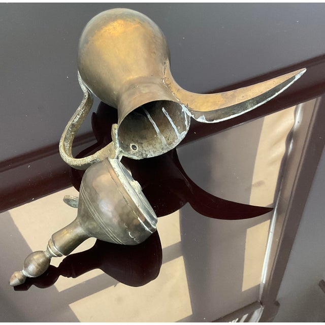 This beautifully crafted dallah, often used for brewing and serving coffee, made of brass, features intricate designs...