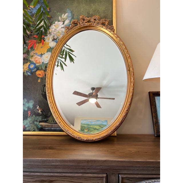 This large Baroque gold ornate frame with a 1 inch beveled mirror is a classic example of a French ribbon bow mirror. The...