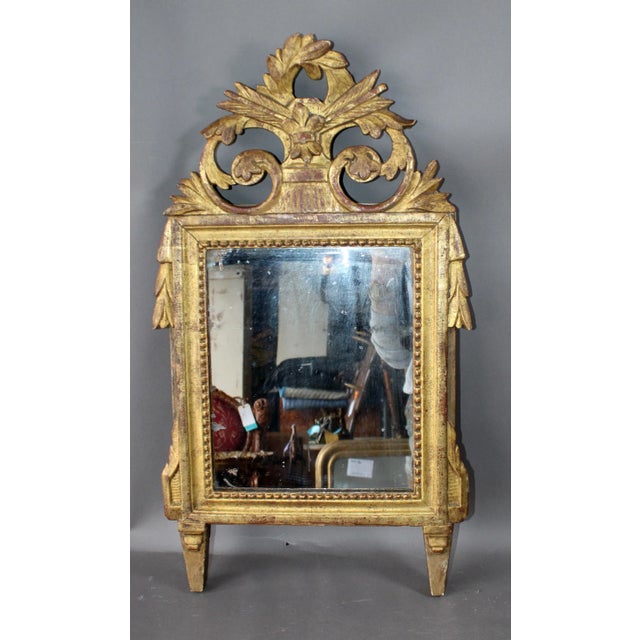 A charming early 19th century French giltwood mirror in the Louis XVI taste, distinguished by its refined carving and...