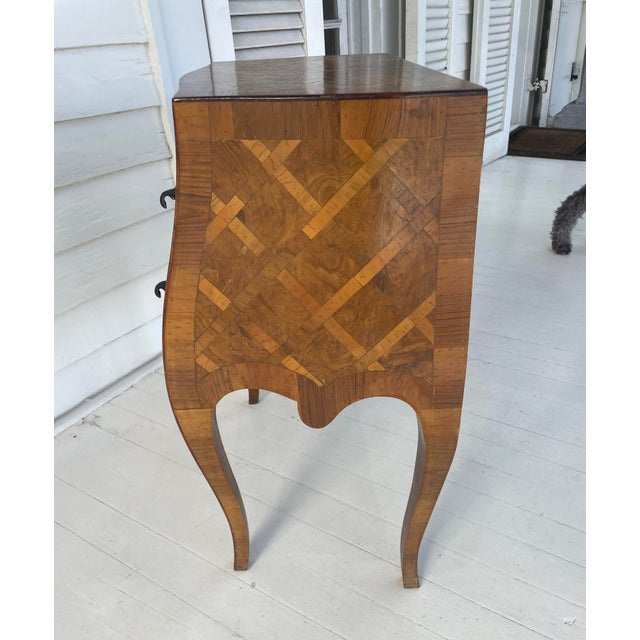 A mid-20th century hand crafted Italian petite commode or side table, commonly known as a commodino. Covered in parquetry...