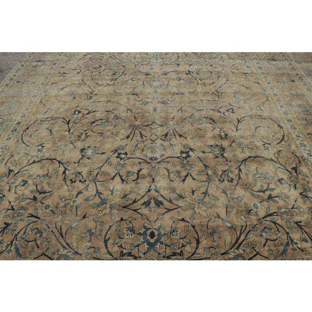 Hand-knotted in wool, this 11x13 antique Kerman rug, circa 1900-1920, is a refined example of Persian weaving celebrated...