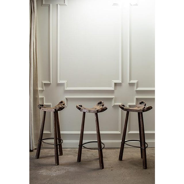 Set of three mid-century wooden bar stools with a sculptural Spanish Brutalist aesthetic. Crafted from exotic wood, each...