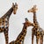 Beautiful set of three XL mid-century hand-painted leather giraffes. These giraffe sculptures made of leather have an...