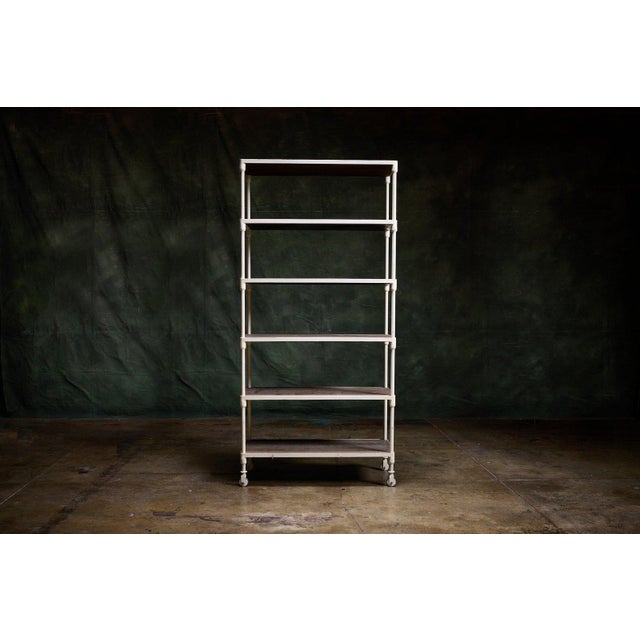 Restoration Hardware 5-shelf industrial bookshelf with white metal frame, weathered wood shelves, and casters. - Five...
