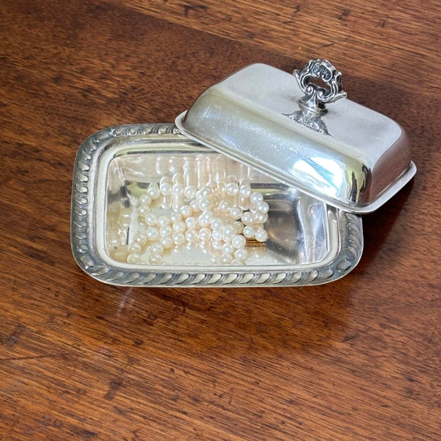 Originally an upscale butter server, it features an ornate scroll border, detailed engine-turned texturing, and a striking...