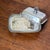 Originally an upscale butter server, it features an ornate scroll border, detailed engine-turned texturing, and a striking...