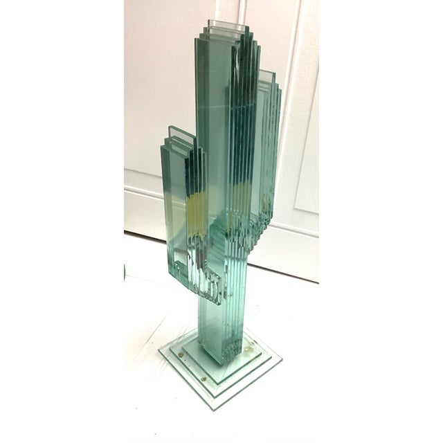 This item is a S. Workman layered glass saguaro sculpture.This piece is crafted from stacked panels of hand-cut glass and...