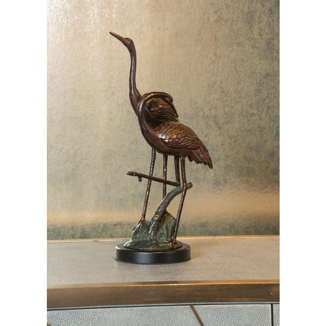 Bring the elegance of nature into your home with this cast alloy hand finished bronze sculpture. A pair of cranes show off...