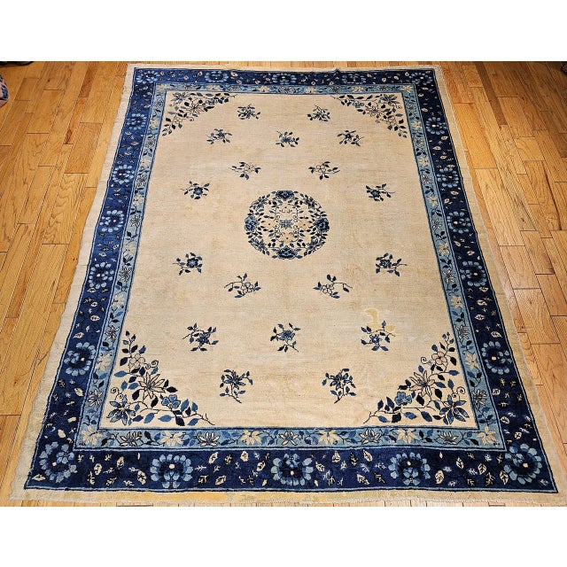 This vintage Chinese Peking rug from the late 19th century features a beautifully soft ivory field of great purity and...