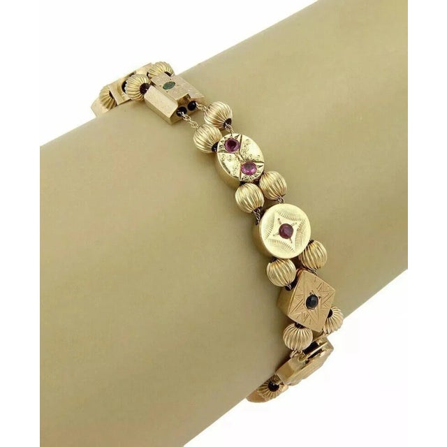 This is a wonderful vintage bracelet, it is crafted from 14k yellow gold in a fine polished finish, It has 11 assorted...