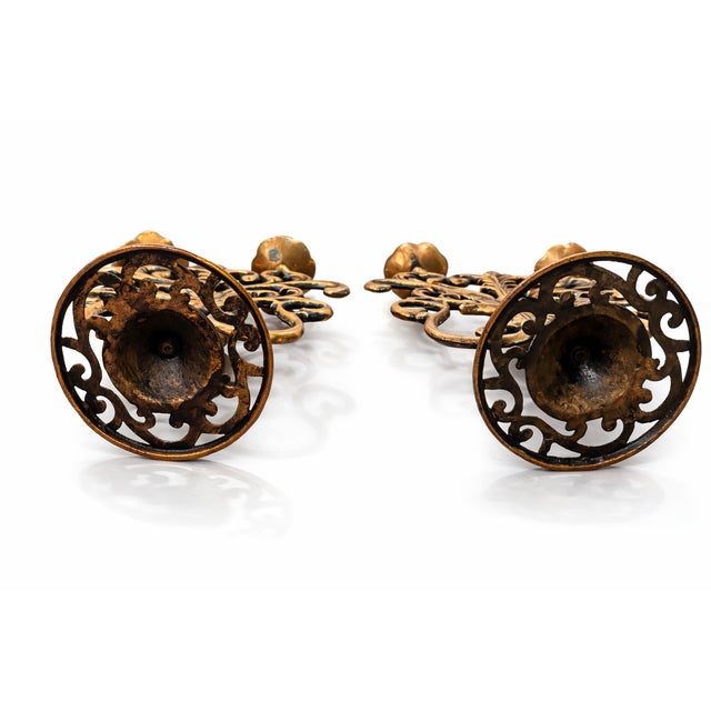 A striking pair of vintage candlesticks featuring an ornate fruit and scrolling foliate motif, finished in a warm copper-...