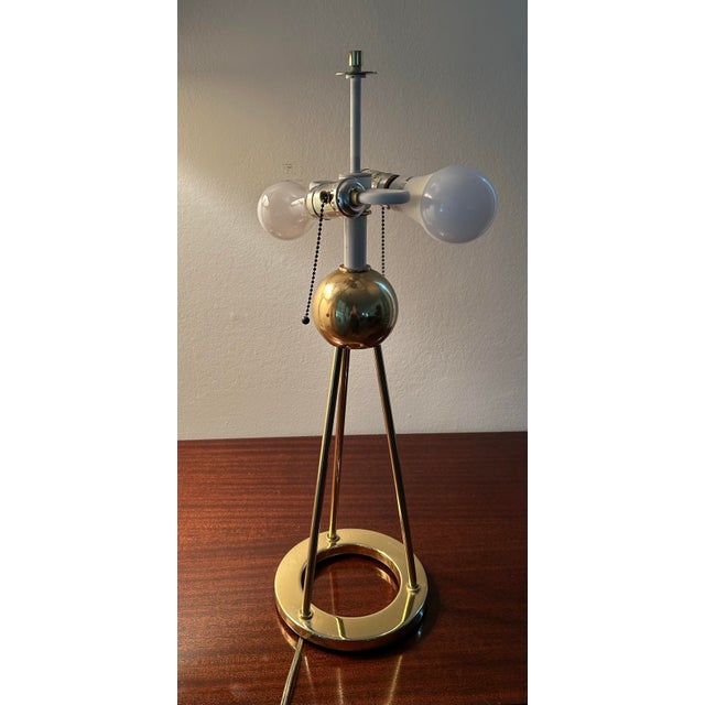 Vintage brass tripod table lamp by Walter von Nessen. Classic minimalist Art Deco shape and form of a ring base with...