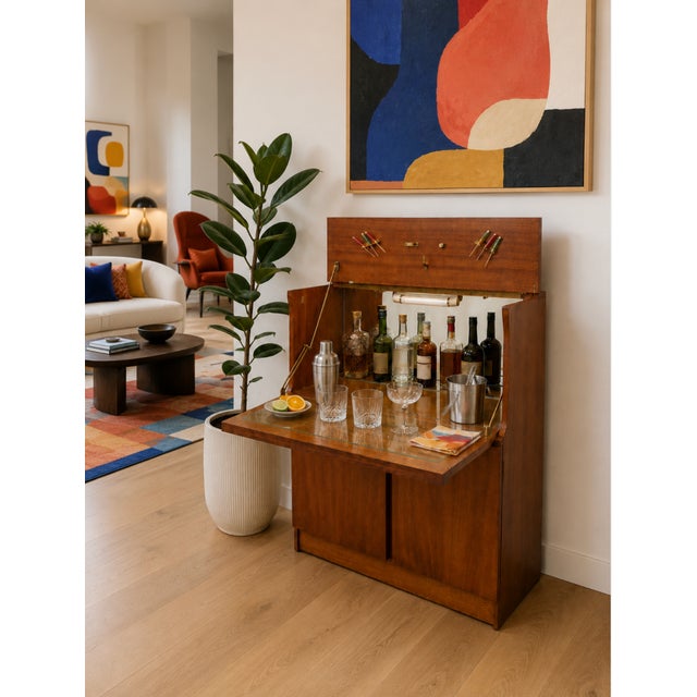 Mid Century Modern Teak bar cabinet that transforms from a compact cabinet into a fully equipped entertaining station. The...