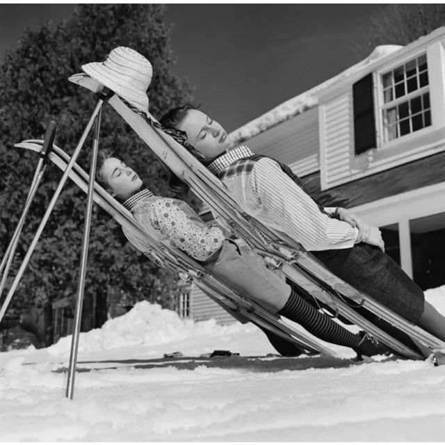 New England Skiing 1955 by Slim Aarons Slim Aarons Limited Estate Edition two women recline on improvised sunbeds in New...