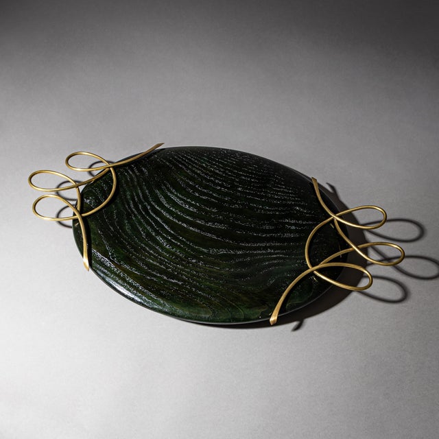 Oval centerpiece bowl in smoothly polished, green-stained wood with loop-shaped brass handles.