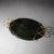 Oval centerpiece bowl in smoothly polished, green-stained wood with loop-shaped brass handles.