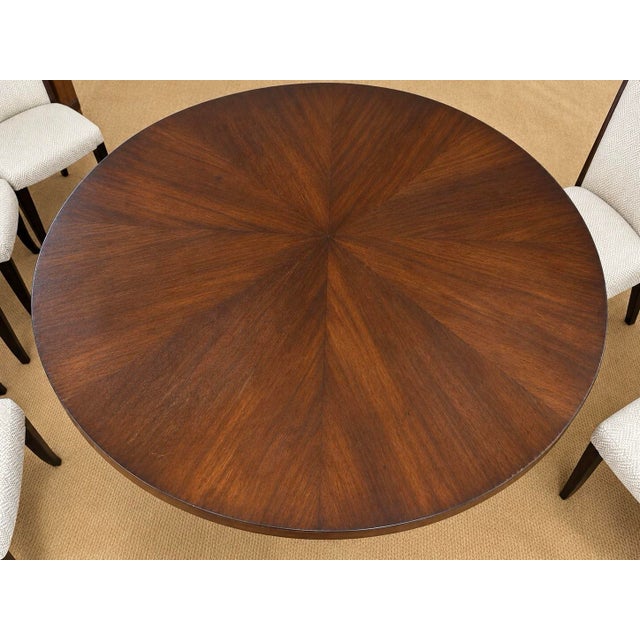 Elegant nine-piece dining set featuring a generously proportioned round 68" wide dining table with a rich, dark wood...