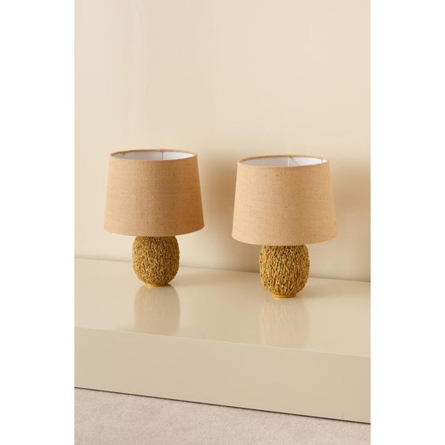 Pair of ceramic table lamps in bulbous shape by Gunnar Nylund, composed of chamotte clay and glazed with a white colored...