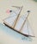 This hand-painted sailboat features meticulously rendered sails - each outlined with fine linework that highlights the...