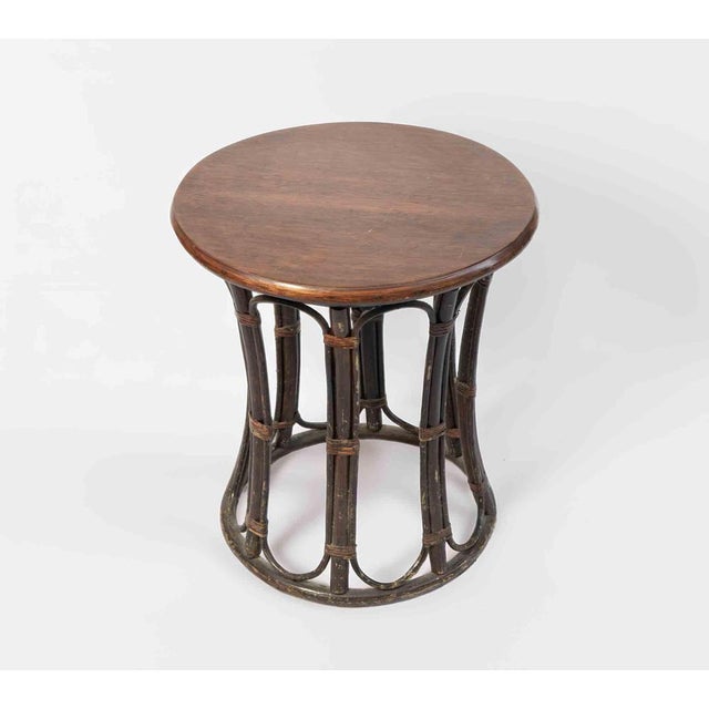 A charming and sculptural three-piece rattan set composed of two “Papasan” armchairs and a matching side table, crafted by...