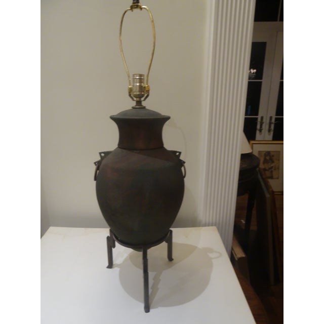 A unique Pottery Lamp that rests on a wrot Iron base with Iron rings on each side.
