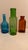 Three small vintage jars in three different shapes and three colors--deep aqua, bottle green and amber brown--to brighten...