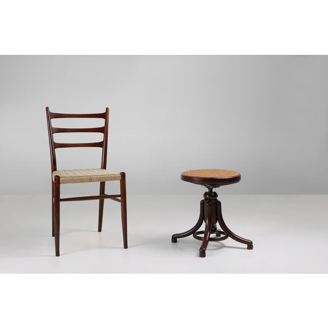 An early 20th century Thonet beech bentwood piano stool with caned seat. This iconic stool was designed by Thonet around...