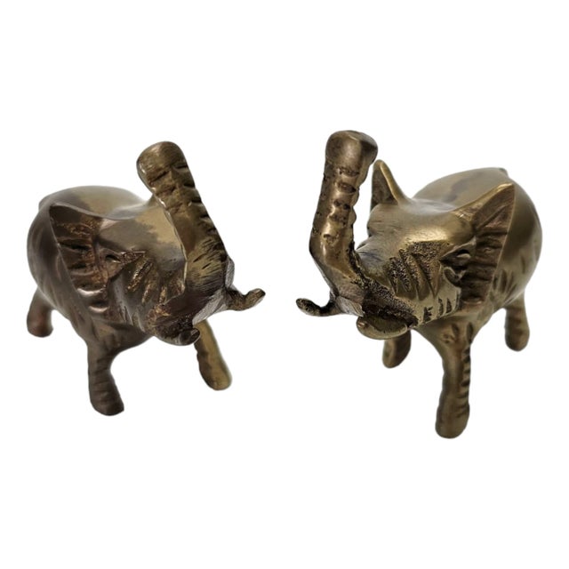 This is a pair of brass elephant figurines that are intricately detailed and made from solid brass. Each elephant has its...