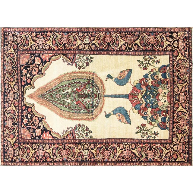 A very fine and unusual antique Persian Feraghan Sarouk featuring an elegant Tree of Life design rising from a flowering...