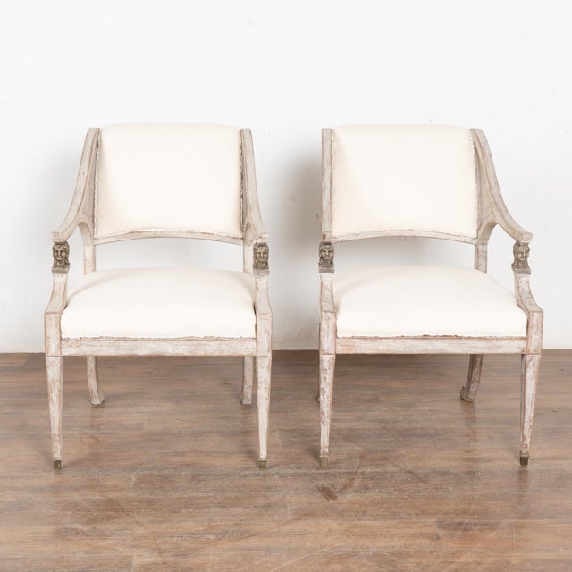 Pair, Swedish Gustavian armchairs with elegant curve to arms into back, balanced with tapered front legs ending with brass...