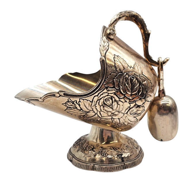 A vessel of sweetness, forged not merely for function but for ceremony. The scuttle rests on its fluted base, rose...