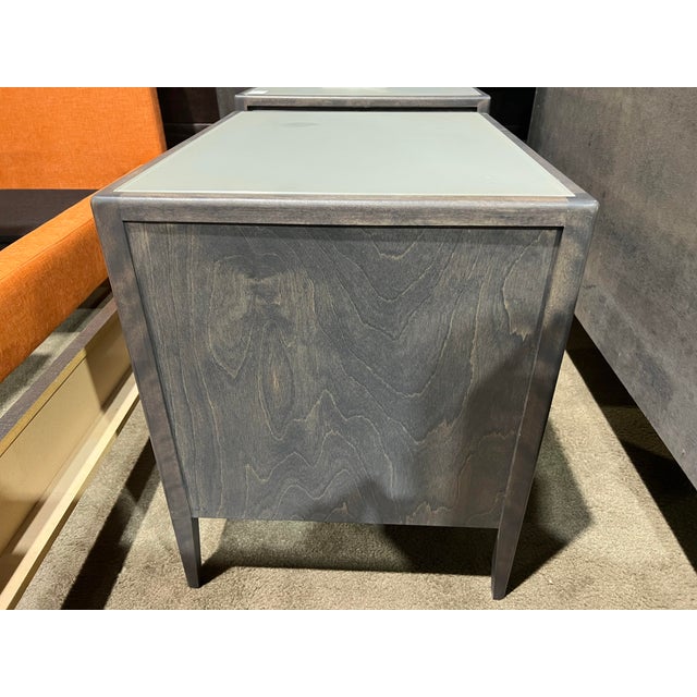 A sleek and modern nightstand from Huppé’s Edmond collection, featuring clean lines and a rich wood finish paired with a...