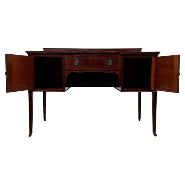An elegant early 20th-century English Edwardian writing table, finely crafted from mahogany and distinguished by its...