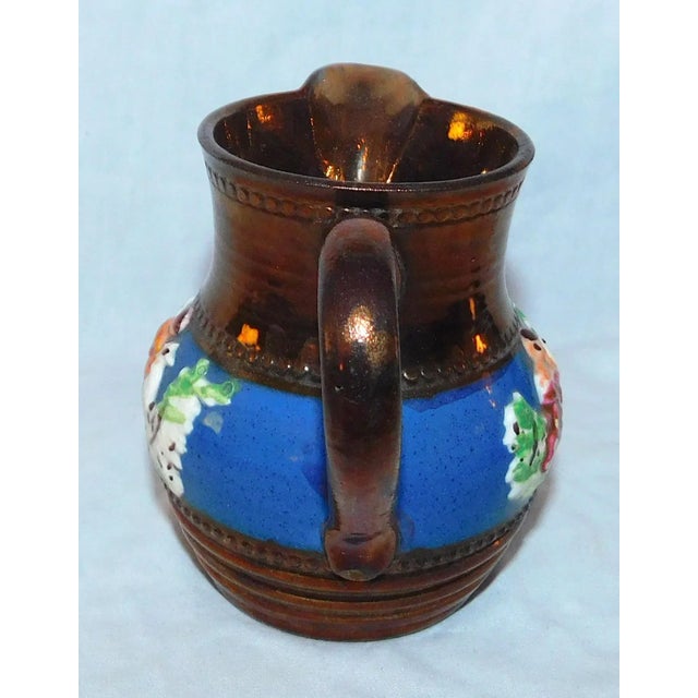 Lovely copper lustre creamer with sprigged figures on a cobalt band. Marked on underside, "Allertons Longton England."