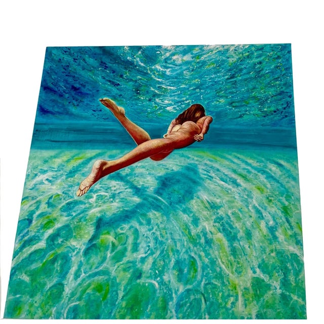 "Floating Weightlessly" is a stunning oil painting of a beautiful nude swimmer, floating through expansive turquoise...