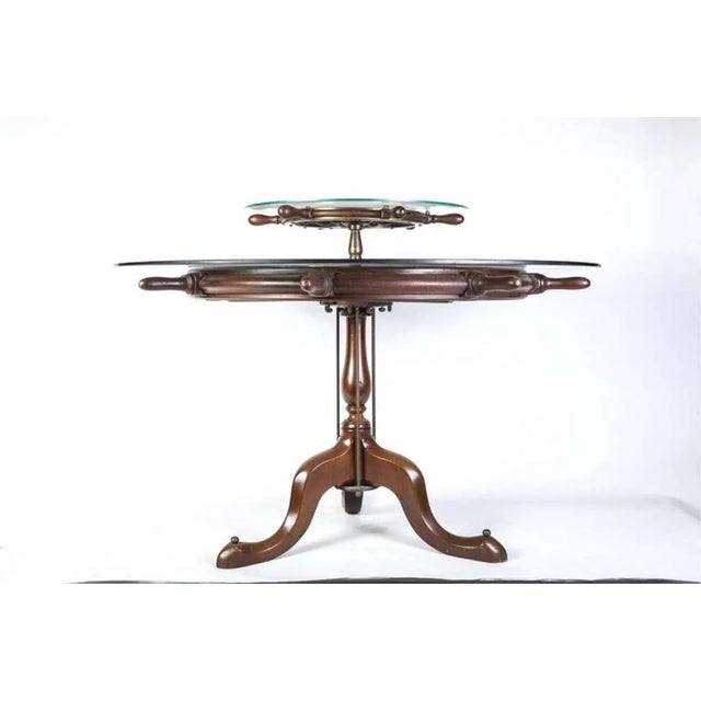 Ship's wheel stamped WWII US Navy with brass mounts adaptively reused as a tabletop for a Queen Anne base with a vasiform...