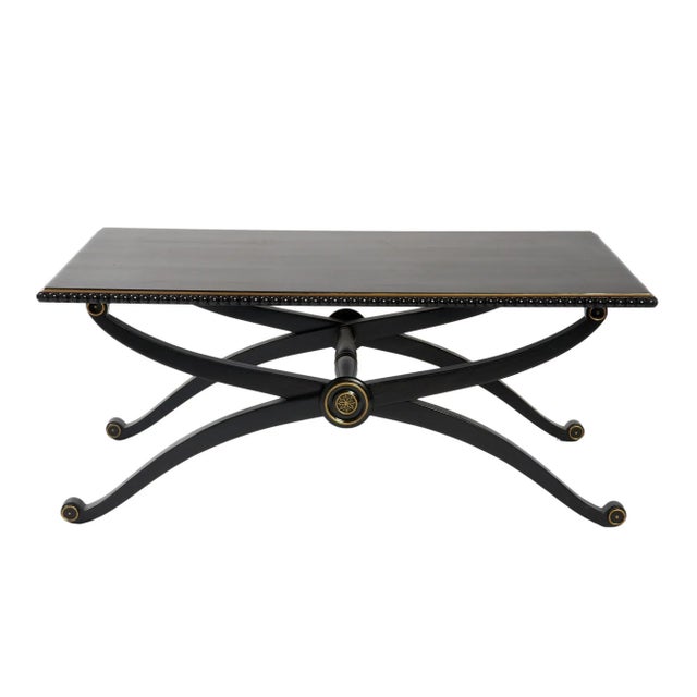 Smooth black lacquer coffee table with X legs and gold accent. Which is modern classical can fit into any room. Matching...
