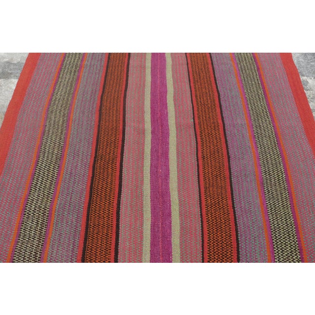 Handwoven in wool circa 1950–1960, this 5x5 vintage Kilim, woven in the tradition of a Frazada textile, is a lively...