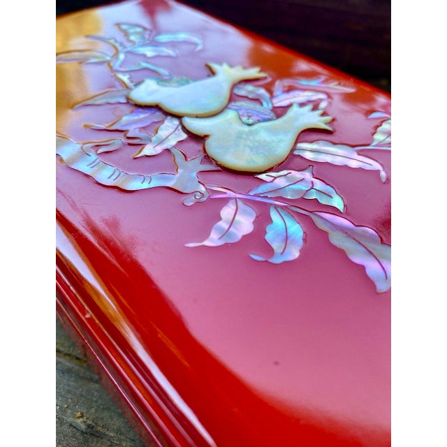 A striking mid-century Japanese lacquer smoking box in a luminous oxblood-red finish with hand-applied mother-of-pearl...