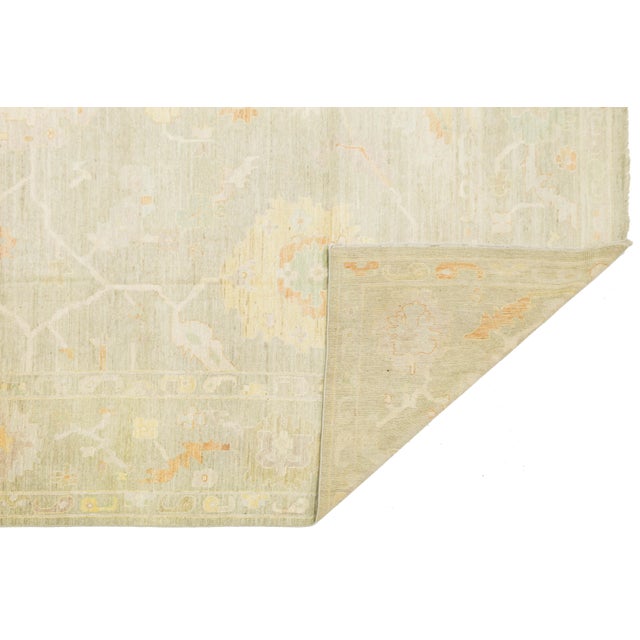 Enhance your interior with this elegant Oushak-style wool rug. Handcrafted to blend traditional Turkish weaving with a...