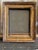 This small wooden frame has a timeworn gold sheen with carved detailing on the inner and outer borders. There is some...