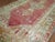 An early 20th century angora wool Oushak rug with a soft watermelon colored ground on an open field and center medallion...