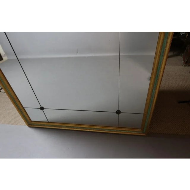 Large 20th Century mirror in green and gold painted wood. This mirror is divided into several parts linked together by...