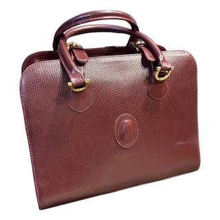 A 1990s Elegant Bordeaux Leather and Brass Top Handle Bag by Cartier For Sale
