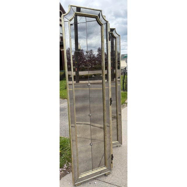 This is a vintage Regency inspired folding screen with antiqued mirrors. The folding screen has a silver leafed frame with...