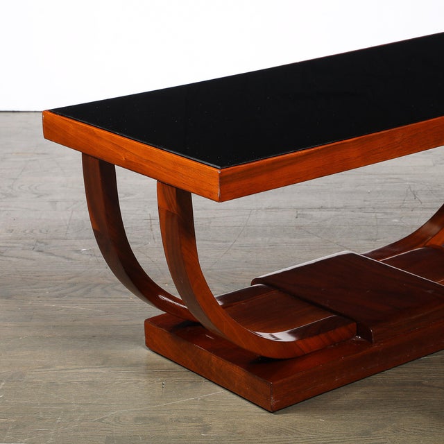 This elegant Art Deco Machine Age Walnut Cocktail Table w/ Inset Vitrolite Top by Modernage originated in the United...